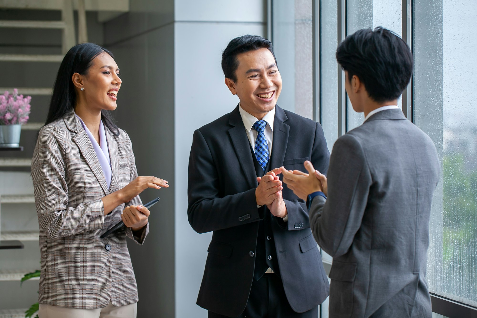 Asian business team celebrate corporate victory together in office.