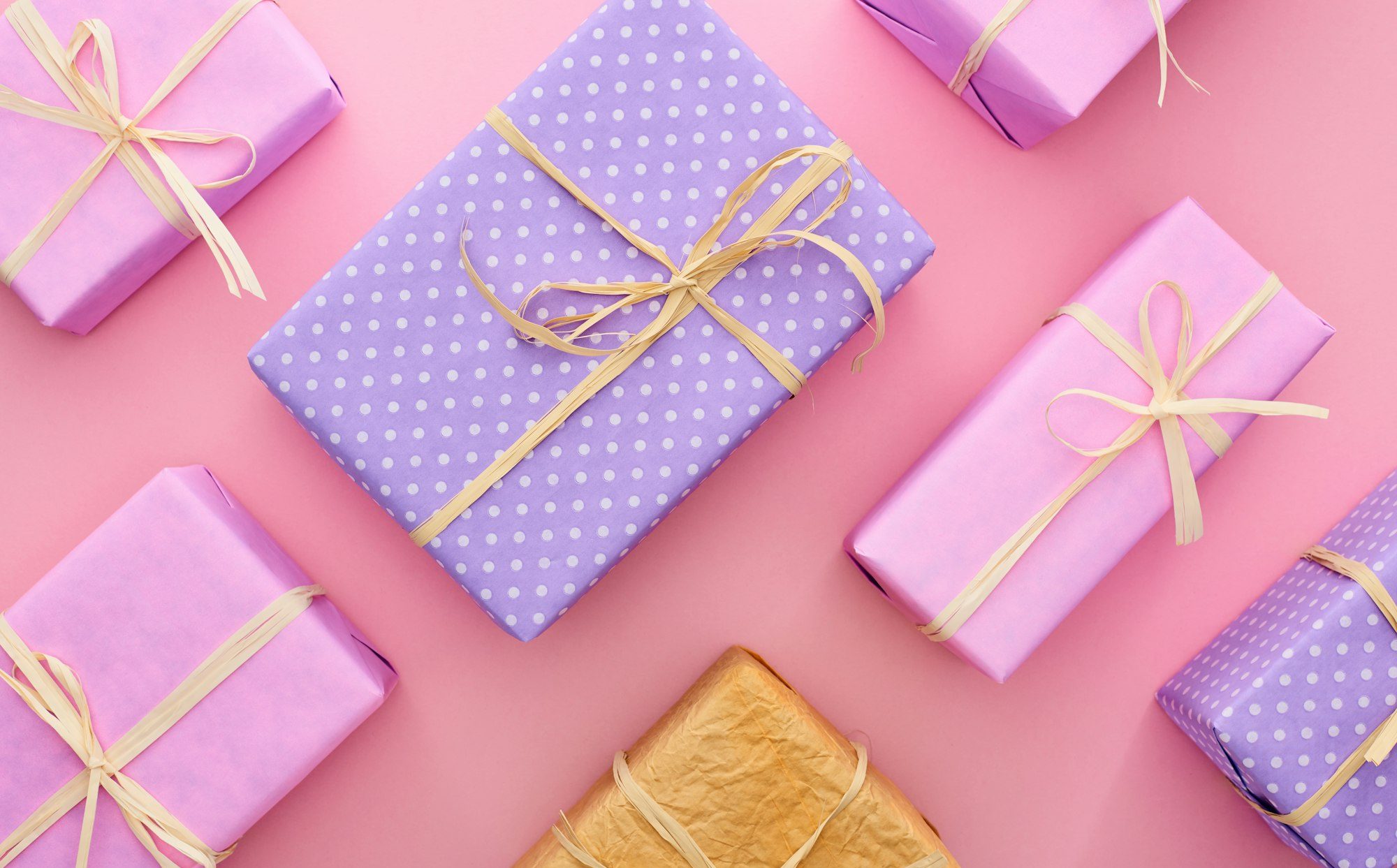 top view of colorful and wrapped gift boxes on pink