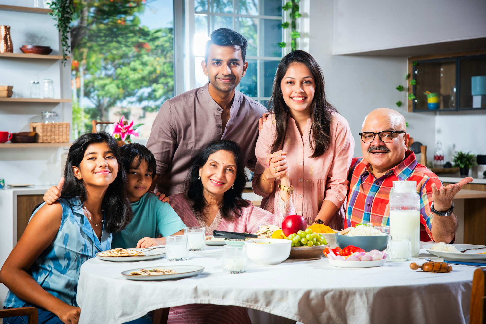 Happy Indian asian family having lunch at home and posing for photo